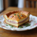 Gâteau jambon fromage parfaitement cuit, servi sur une assiette décorative.