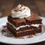 Delicious slice of chocolate banana cake with whipped cream, perfect for dessert.