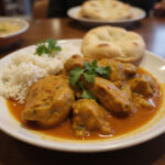 Finished Poulet Curry served with rice and naan, ideal for a delightful dining experience.