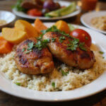 Delicious Mafé Poulet served with rice, colorful vegetables, and garnished with herbs, perfect for a comforting meal.