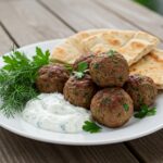 Serving of Boulettes grecques with tzatziki sauce, perfect for a Mediterranean meal.