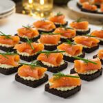 Finished canapés de saumon fumé on black bread, perfect for elegant hors-d'œuvre.