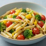 Finition de recette de pâtes saines avec légumes pour un repas rapide et savoureux.