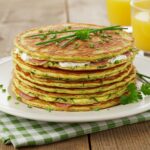 Delicious pancakes salés aux courgettes, chèvre et jambon arranged beautifully for a tasty petit déjeuner.