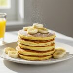 Finished pancakes légers au yaourt with banana slices and powdered sugar, perfect for a healthy breakfast.