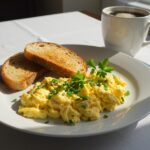Fluffy scrambled eggs ready to serve as a delightful recipe for œufs brouillés for a perfect breakfast.