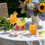 Decorative table displaying cocktail spritzes with melon and rosemary, perfect for summer gatherings.