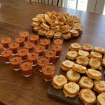 Table setting featuring tomato soup shooters and mini grilled cheese for delightful amuse-bouches.