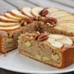 Tranche de gâteau aux pommes et noix sans gluten, prête à être servie.