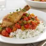 Finished poulet à la catalane served with rice, an excellent representation of Mediterranean cuisine.