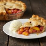 Tarte de pêche et rhubarbe délicieuse avec de la glace à la vanille, parfaite pour les desserts estivaux.