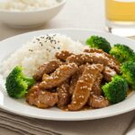 Delicious sauté de bœuf haché au miel et à l'ail, served with rice and broccoli.