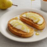 Deliciously finished Toast à la Poire with pear slices and honey, a sweet treat ideal for breakfast or dessert.